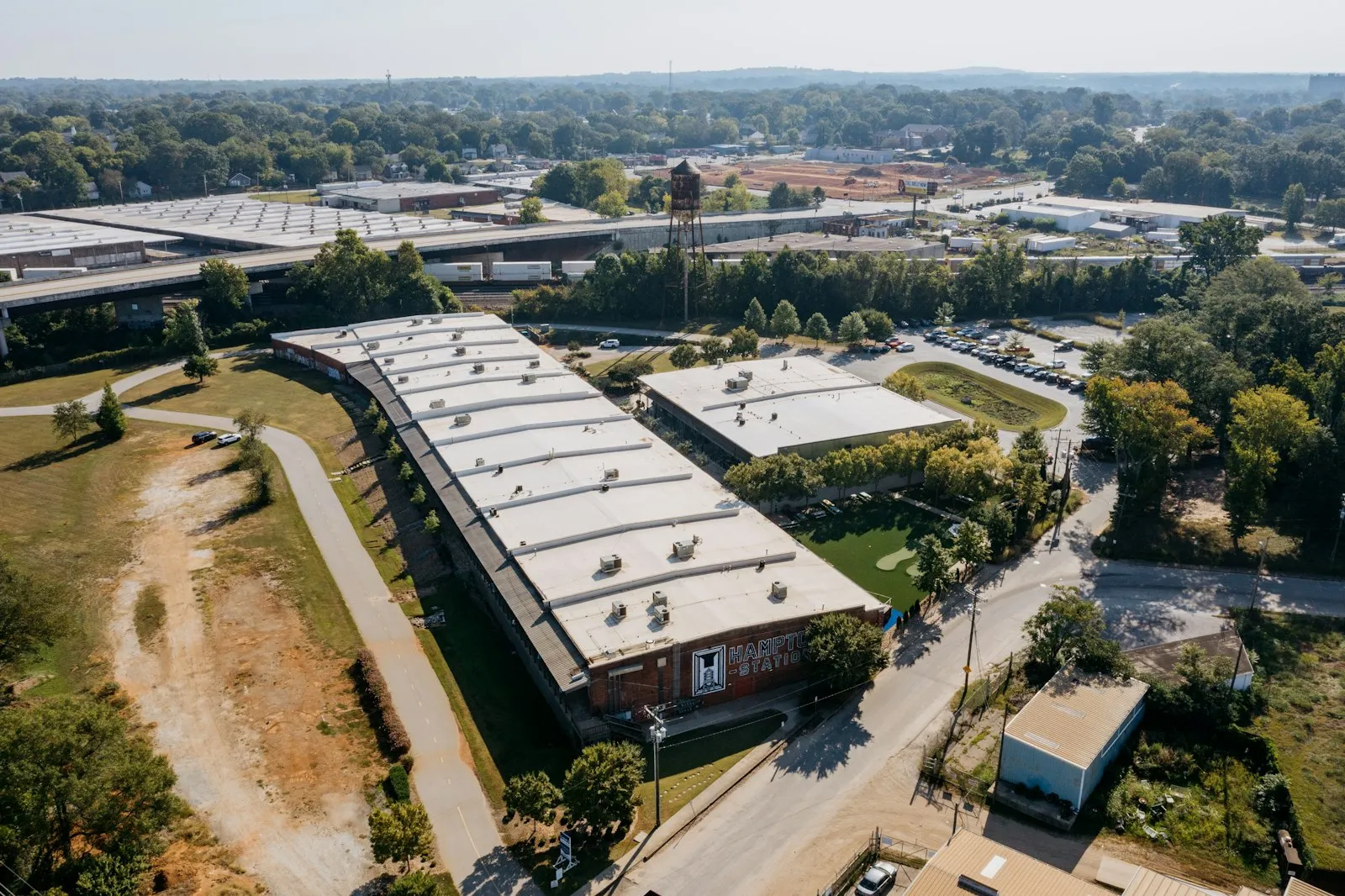 An aerial view of an industrial park set in a green, small-town landscape